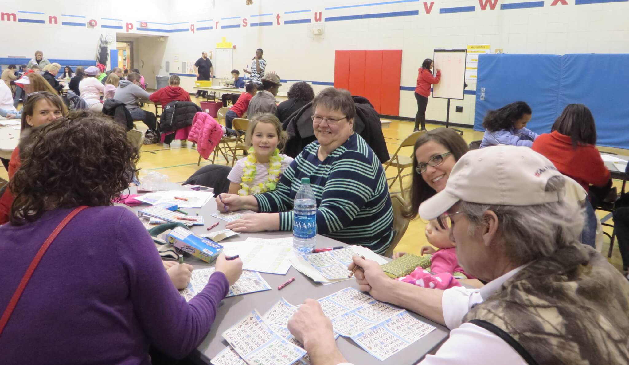 Family playing BINGO in a gym