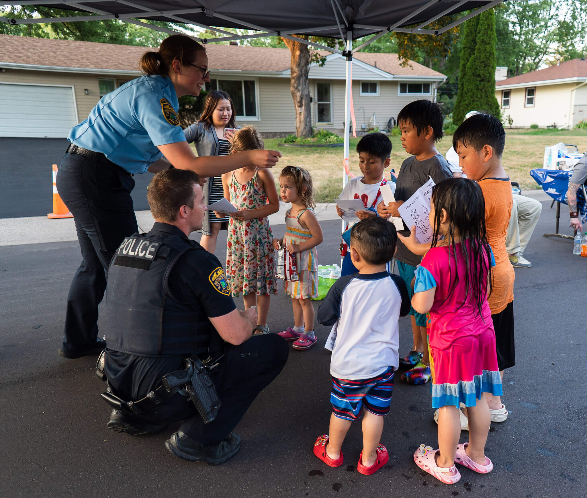 Police interacting with kids in a neighborhood.