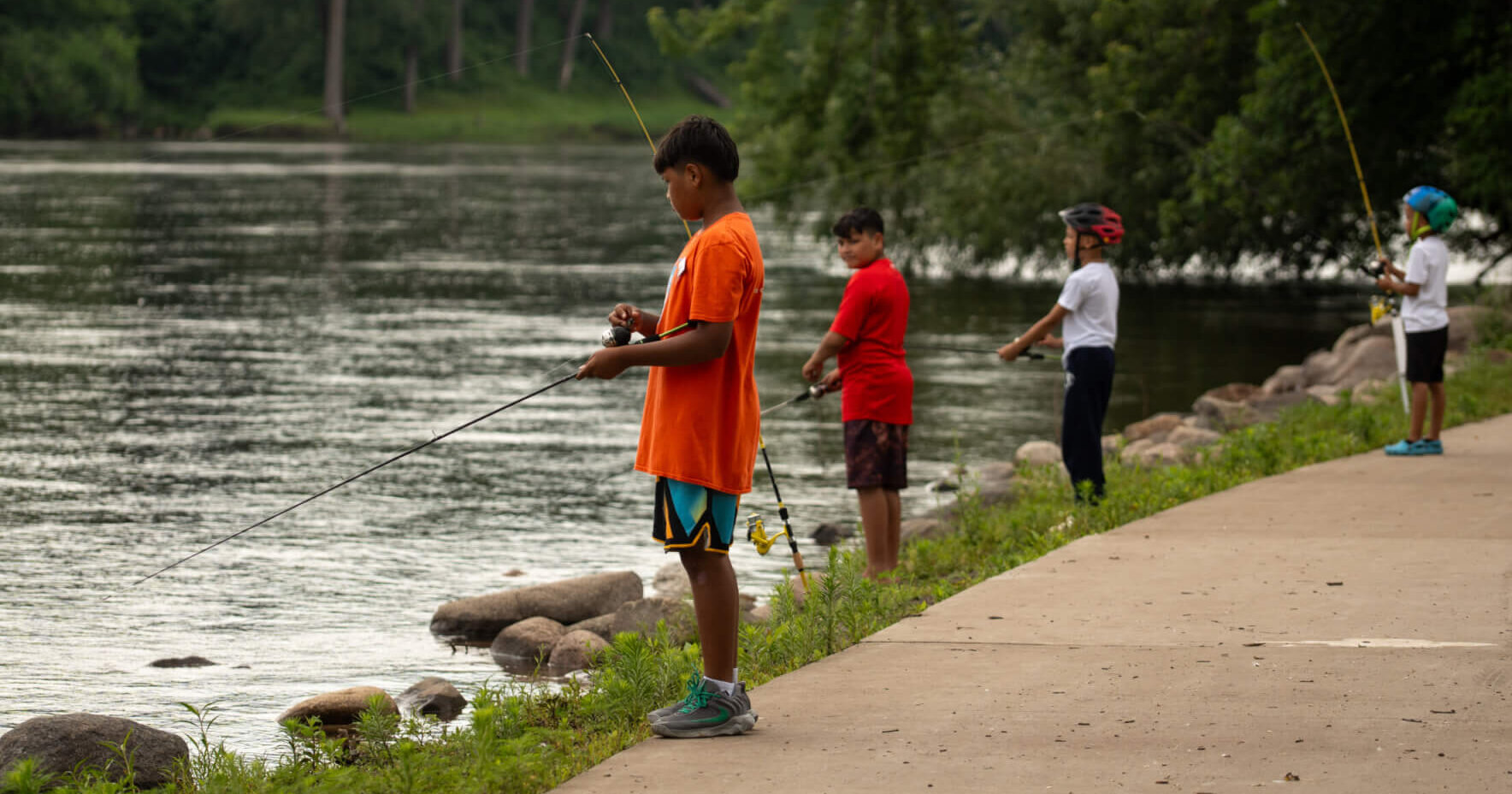 Four kids fishing on the banks of the Mississippi River