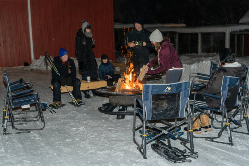 People around a bonfire after snowshoeing