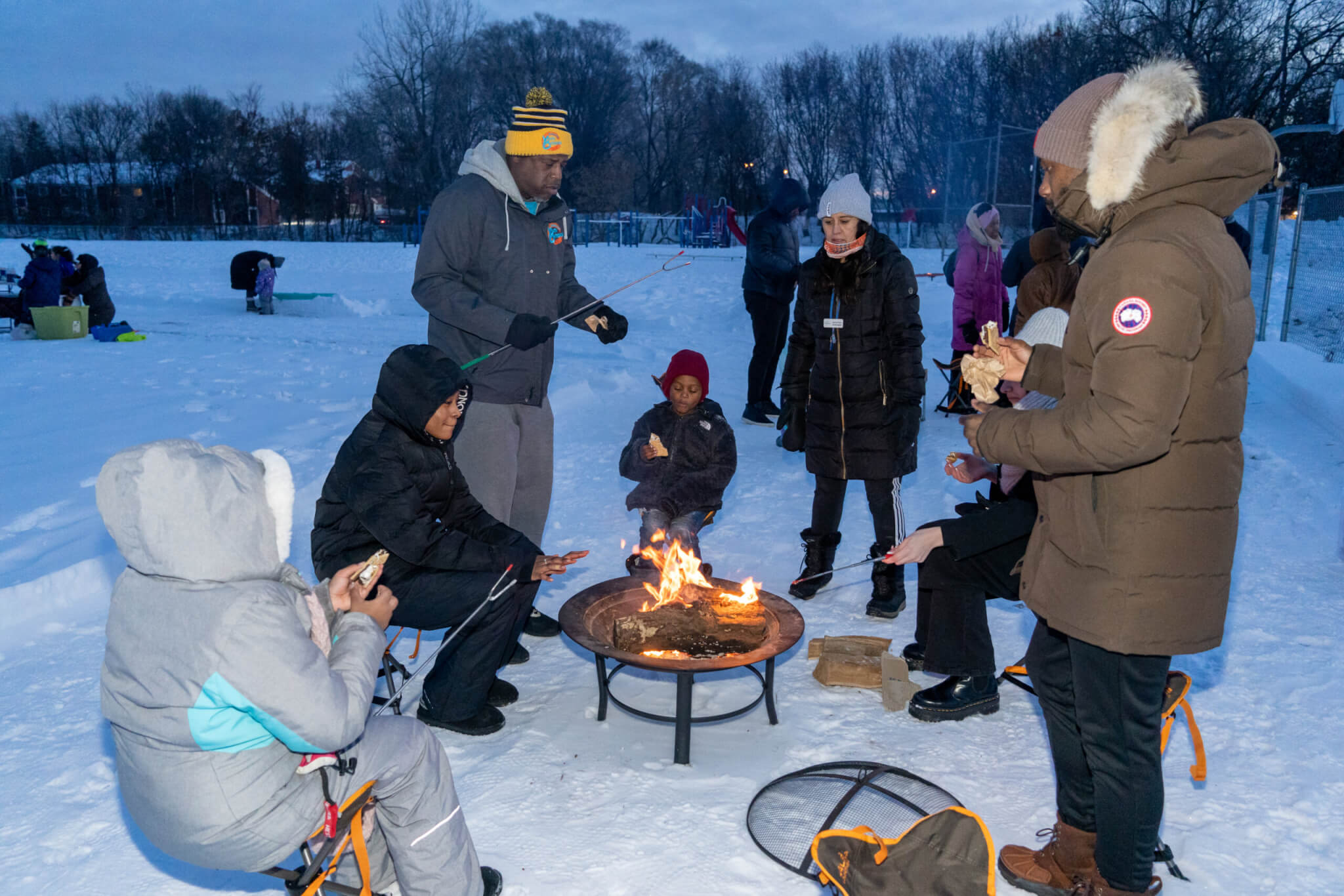 People around a bonfire making s'mores