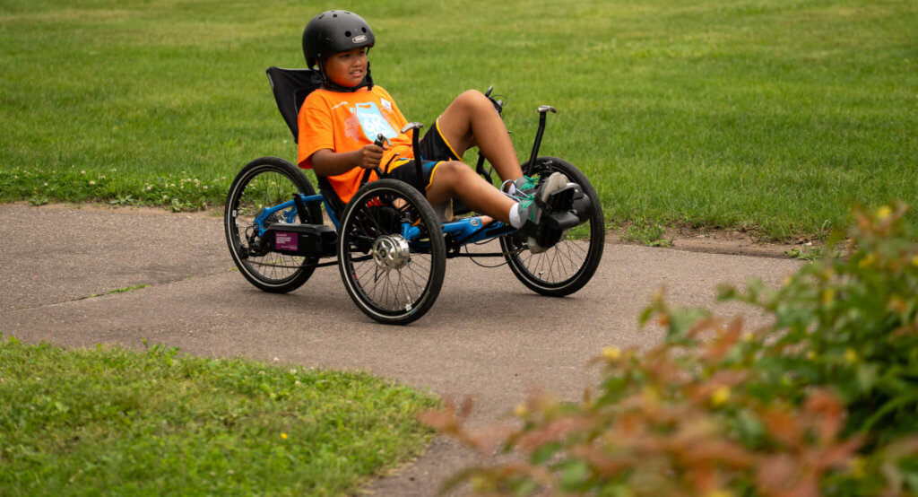 Kid riding a four-wheel bike on a bike path